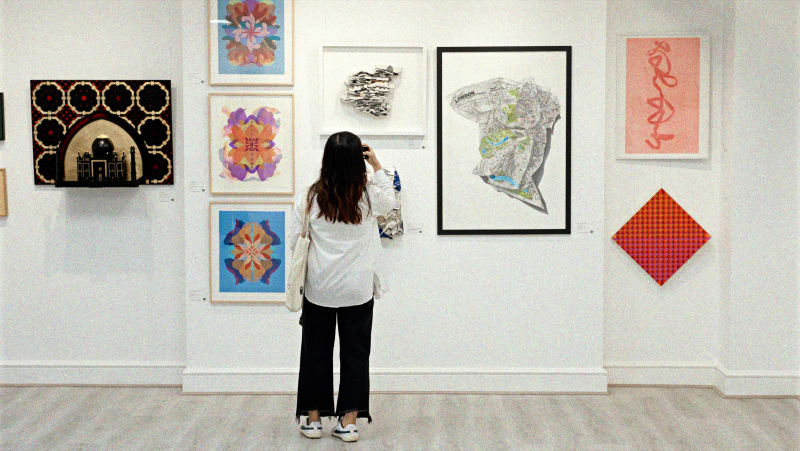Woman photographing artwork at the square mile summer exhibition 2025 at crane court gallery