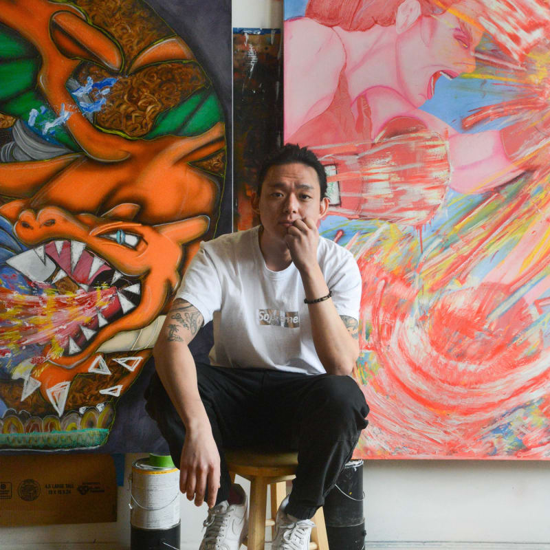 photo of the artist David Heo in the studio with two (partial view) large scale paintings in background