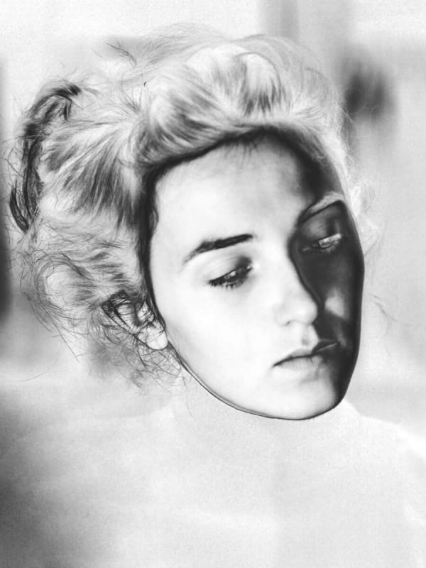 solarized photograph of white woman's slightly tilted head with her long hair tied up