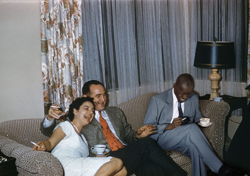 Image from The Anonymous Project archive with Omar Victor sitting on a couch laughing with two anonymous white individuals