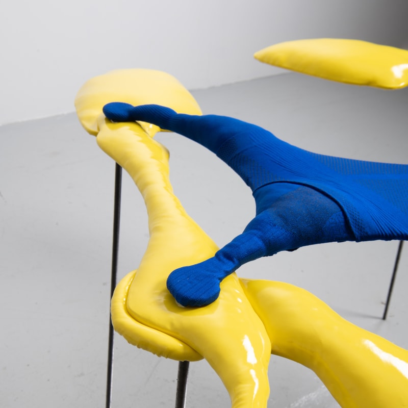 Artwork detail of artwork 'Splat' abstracted two figures in yellow made of vinyl with a blue fabric linking them together