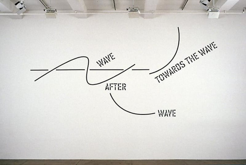 Words on a wall that read: Wave After the Wave Toward the Wave, with lines near the words