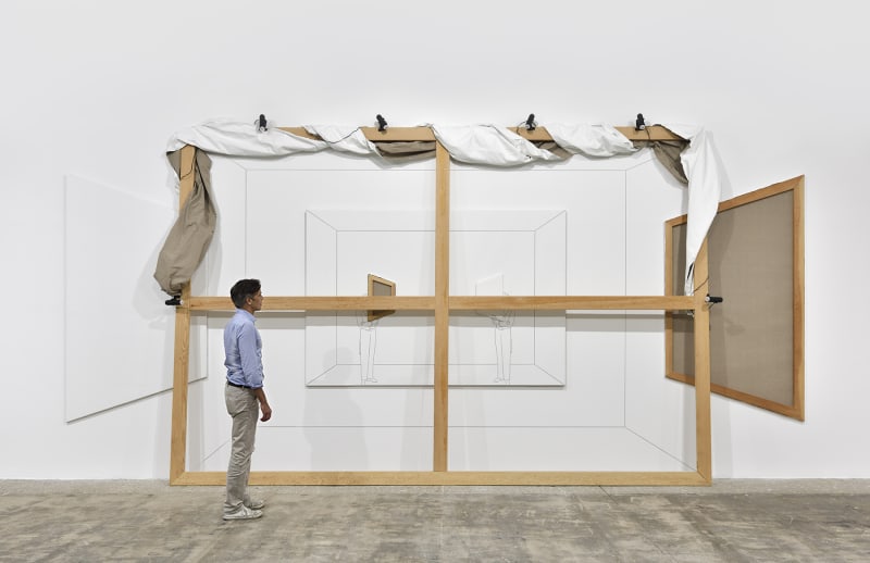 a man stands next to a large scale work by Giulio Paolijni