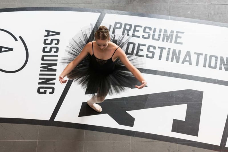 ballerina curtsies on Lawrence Weiner's work Out Of Sight
