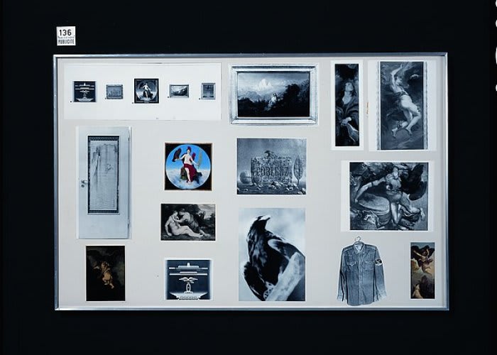 Blue-tinted collage of various aged photographs in s display case against black backdrop.