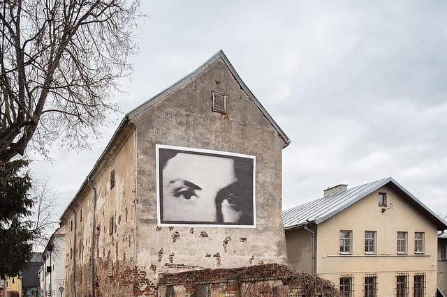 black and white photo of woman's face on facade of house