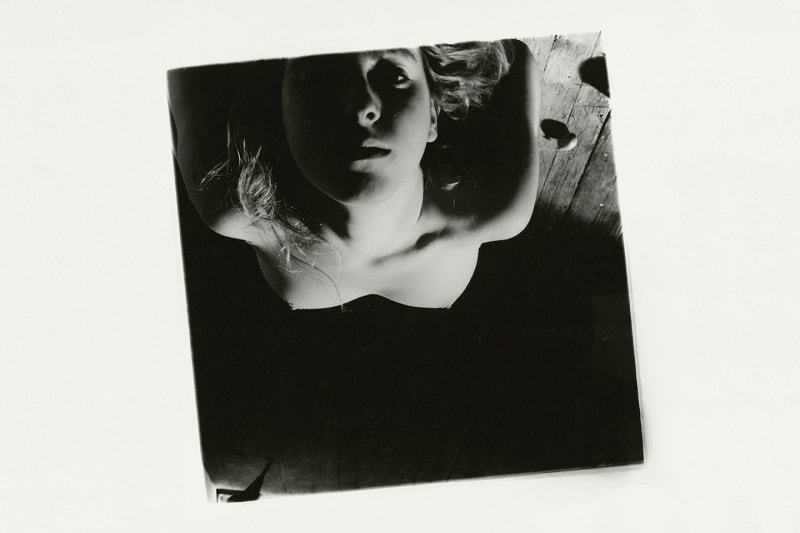 The artist herself, bending backwards and facing the camera with a pervading gaze.