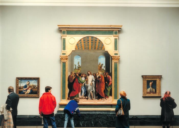 Image of five spectators viewing various renaissance artworks on a museum wall.