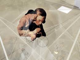 Figure crouches on floor holding a paint brush as geometric lines fold over them.