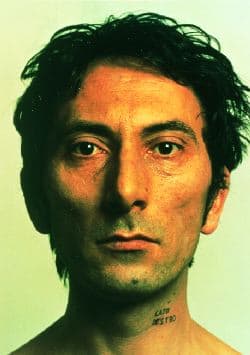 Close up portrait of face. Strong use of green shadows in the face. Subject has a tattoo on left side of neck.