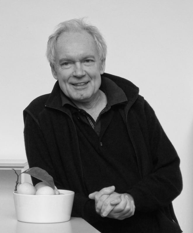 black and white portrait of Lothar Baumgarten leaning on a table with bowl of limes.
