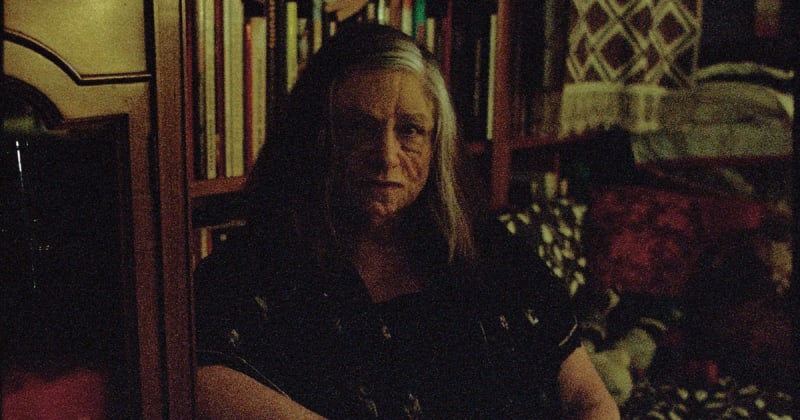 Grainy photo portrait of person in dark room.