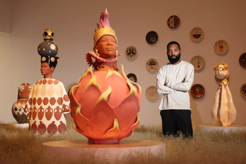 “The Day Tomorrow Began,” Tavares Strachan’s show at LACMA, reflects his passion for science as well as his desire to showcase inspiring figures from Africa and the Black diaspora. Here, he stands in field of rice grass next to ceramic sculptures honoring