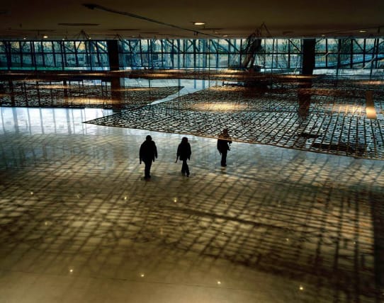 Three figures walking through a building from afar.