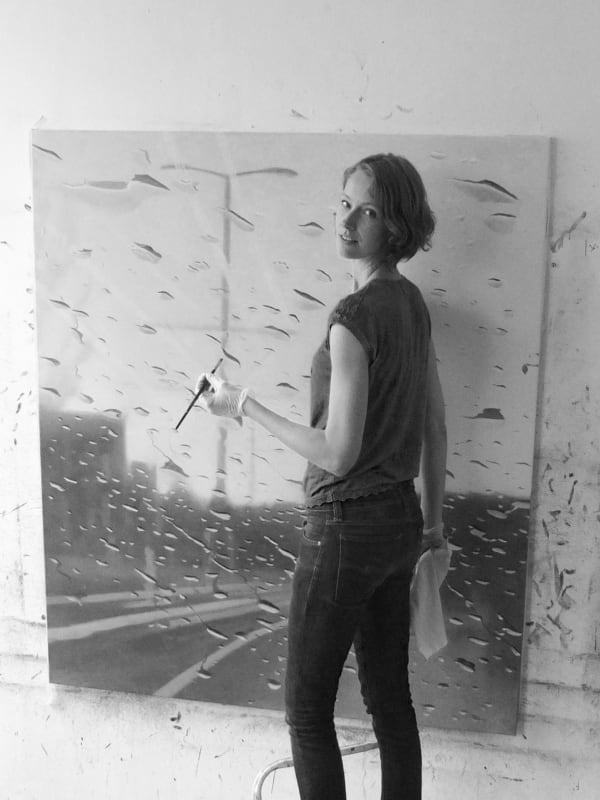 A black and white photo of Dutch artist Esther Nienhuis in her studio.
