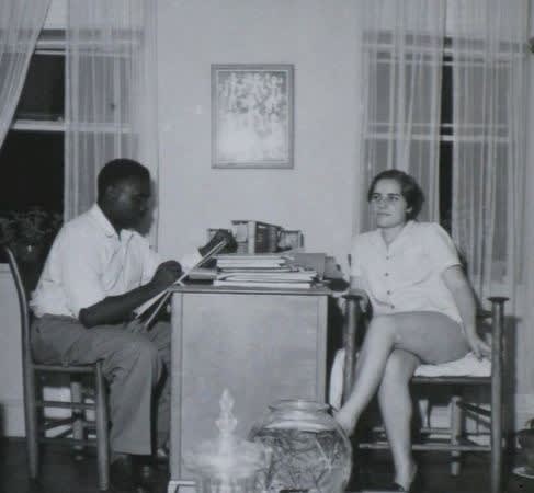 A man and woman sit across from each other at a table. 