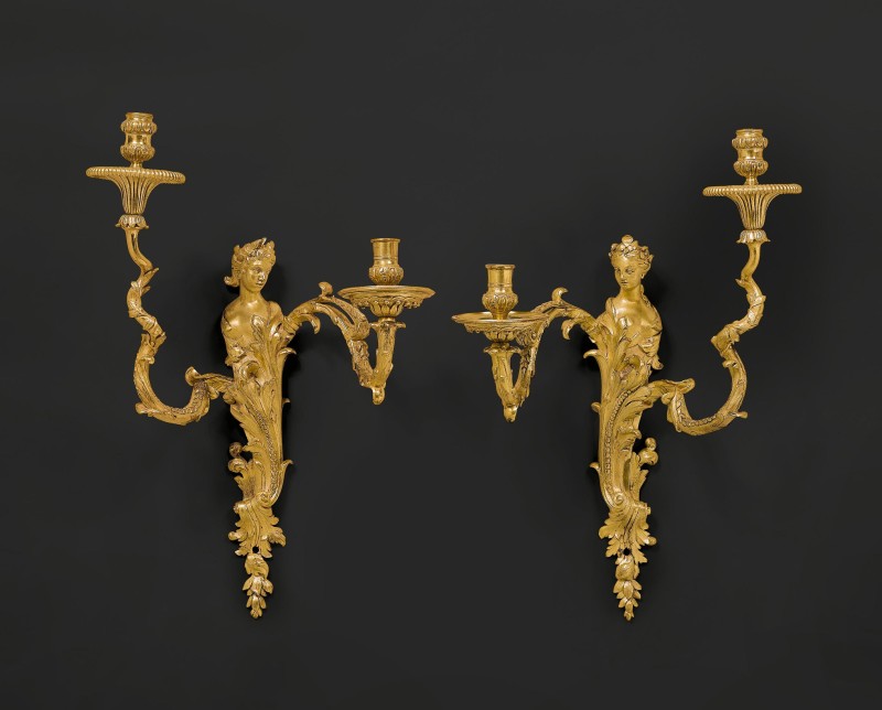 A pair of Règence two-light wall-lights, almost certainly after a design by Gilles-Marie Oppenord, Paris, date circa 1730