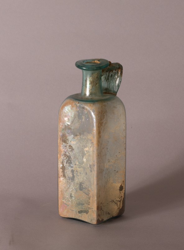 Roman green glass prismatic bottle , 1st-2nd Century A.D.