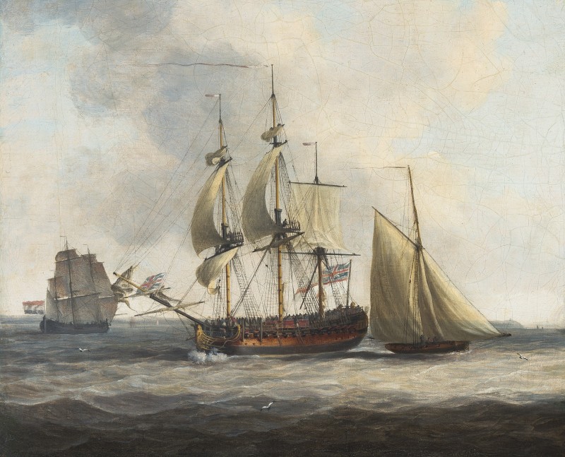 A British Frigate at sea flanked by a tender
