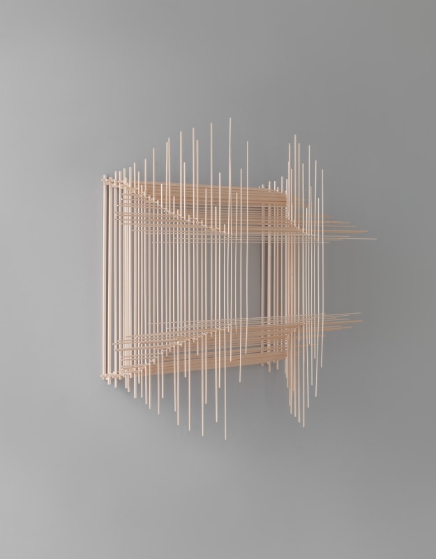 Ausschnitt aus der Perspektive einer abstrakten Skulptur, die durch Übereinanderlegen zahlreicher Balsaholzstäbchen, Baumwollfaden und Leim hergestellt wurde.
