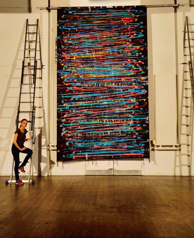 Alice Anderson in her studio at the end of confinement next to her performative painting 'Social Distancing', 2020.