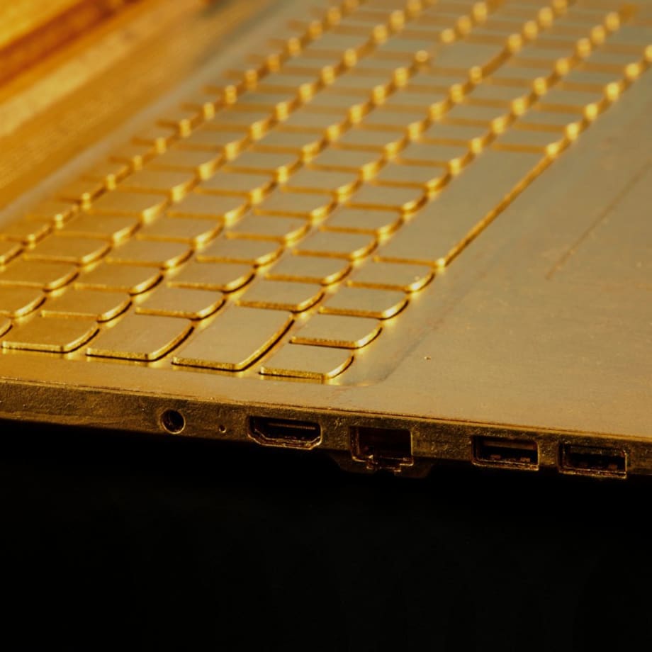 Keyboard detail of Article 3, a 2023 sculpture by Nic Phillipson, featuring a laptop computer gilded in 24 karat gold leaf