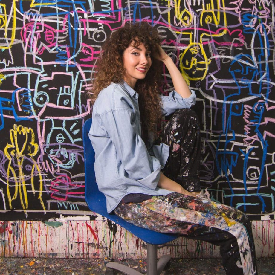 Artist Lara Padilla in the studio with paintings