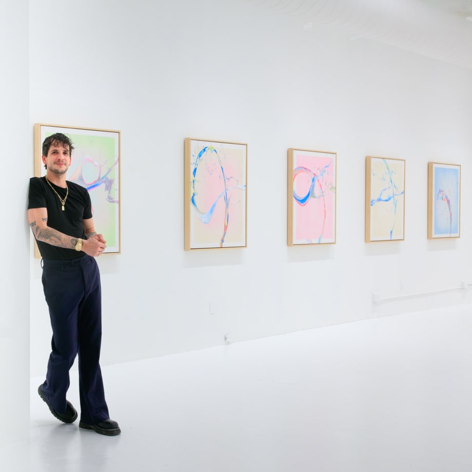 Cevin Parker at his exhibition Behind A Dream with artworks hanging on wall