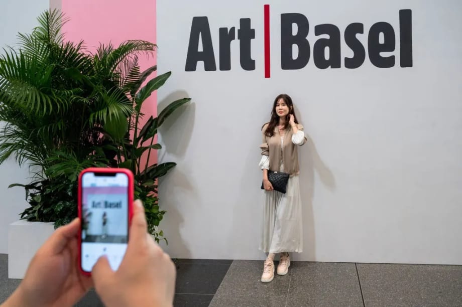 A visitor poses for a photo at the entrance of the Art Basel Hong Kong show after several years of remote and hybrid events due to covid restrictions in Hong Kong. SOPA Images/LightRocket via Getty
