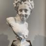 A bust of a woman with flowers in her elaborate hair