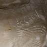 The signature on the rear of a figure of a crouching woman roughly hewn from a piece of alabaster